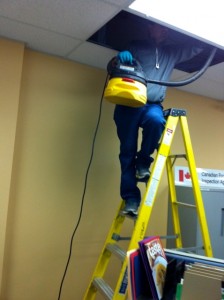 Our staff getting right into the ceiling tiles with a vacuum to give a thorough cleaning